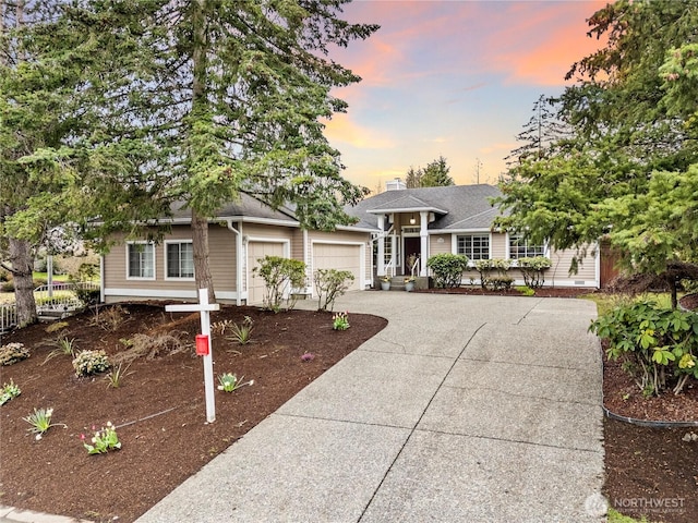 view of front of property with a chimney, concrete driveway, an attached garage, and a shingled roof