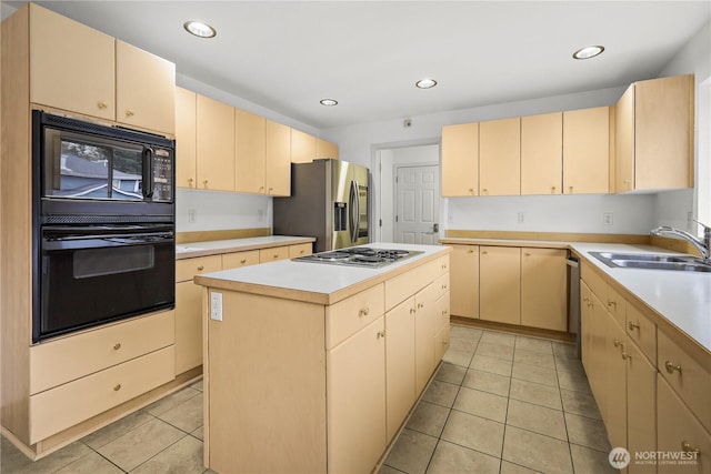 kitchen with a center island, light countertops, light tile patterned floors, black appliances, and a sink