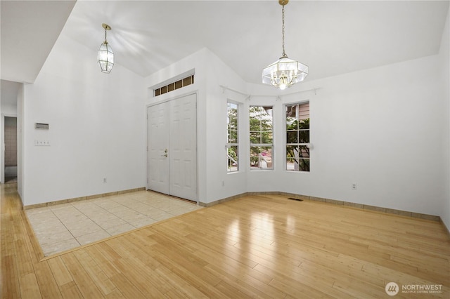 entryway with visible vents, baseboards, an inviting chandelier, and wood finished floors