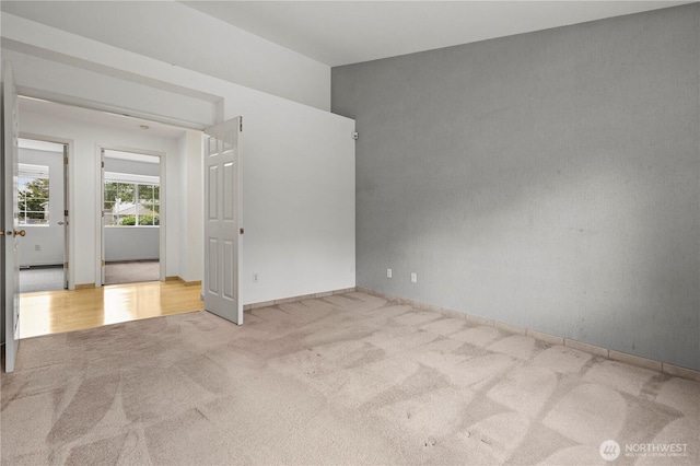 unfurnished room featuring baseboards and carpet