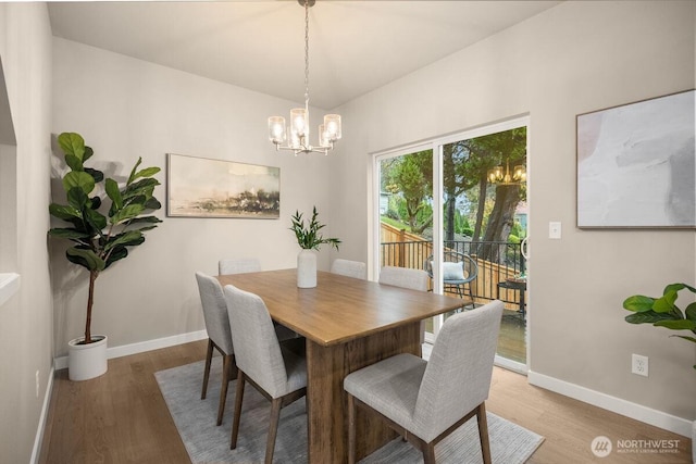 dining room with an inviting chandelier, baseboards, and wood finished floors