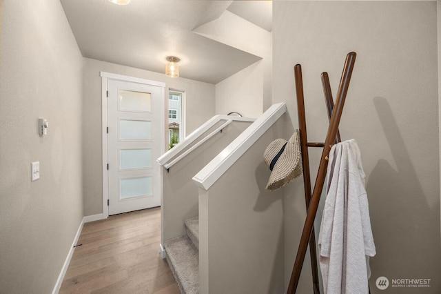 stairway with baseboards and wood finished floors