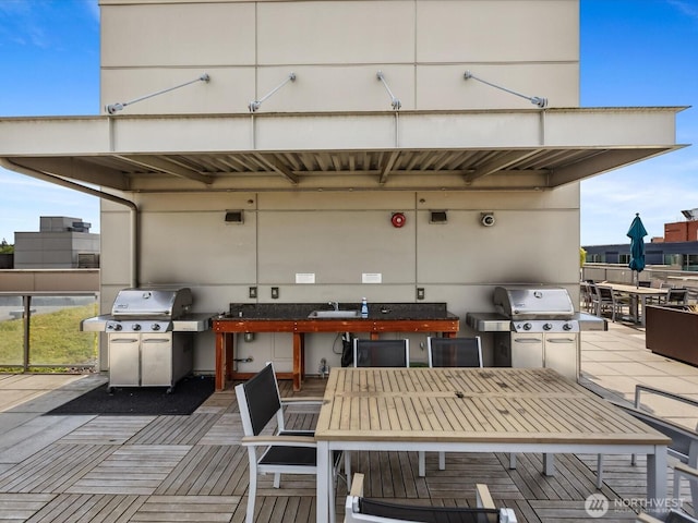 view of patio featuring a sink, outdoor dining area, and a grill