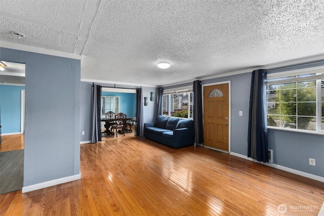 unfurnished living room featuring a wealth of natural light, baseboards, and hardwood / wood-style flooring