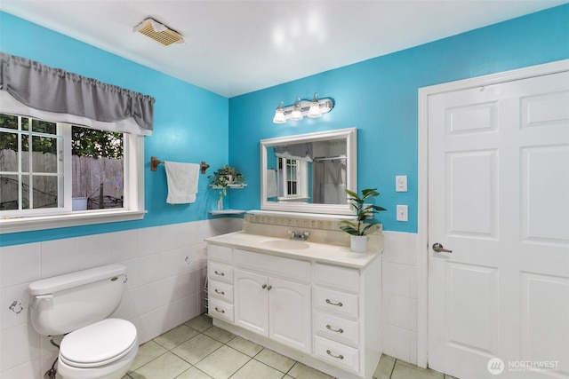 full bathroom featuring toilet, vanity, visible vents, and tile patterned floors