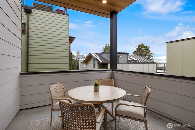 view of patio with a balcony and outdoor dining space