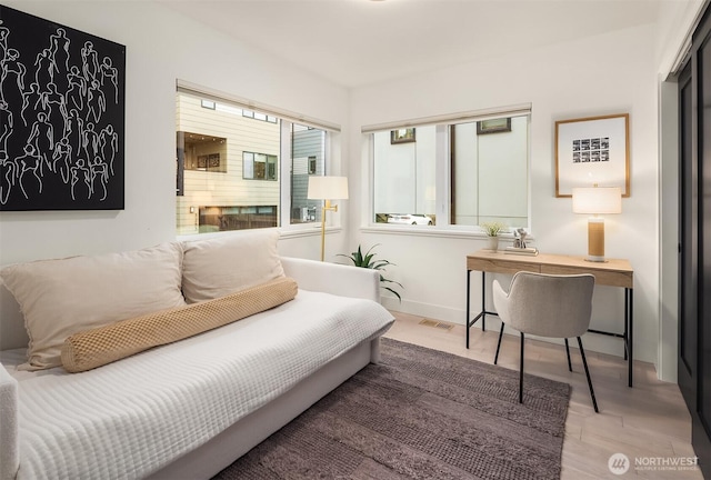 interior space with baseboards, visible vents, and wood finished floors