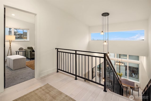 hall featuring recessed lighting, baseboards, wood finished floors, and an upstairs landing