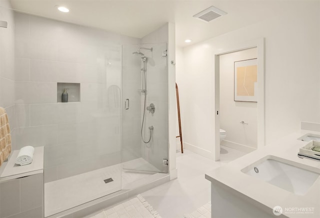 bathroom featuring visible vents, a shower stall, toilet, and baseboards