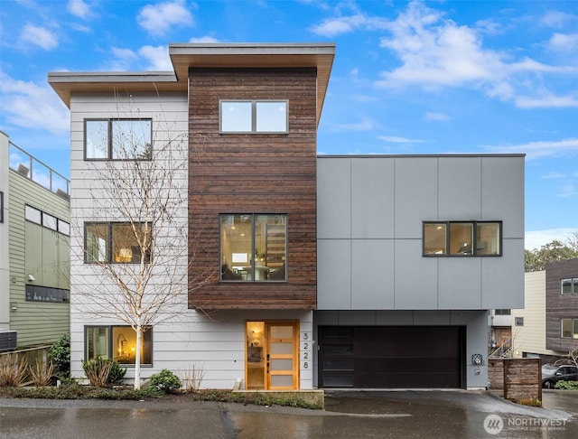 contemporary house featuring a garage and aphalt driveway