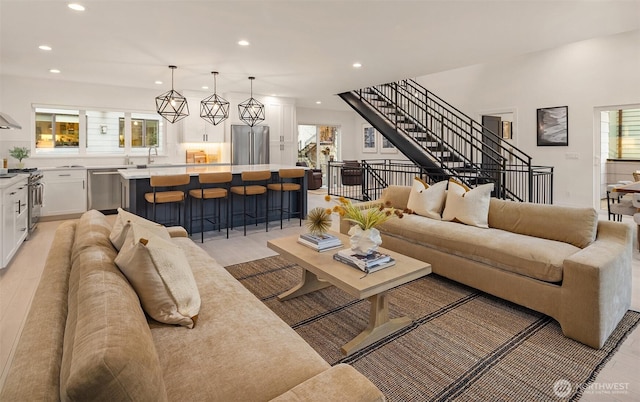 living area featuring stairs, light wood finished floors, and recessed lighting