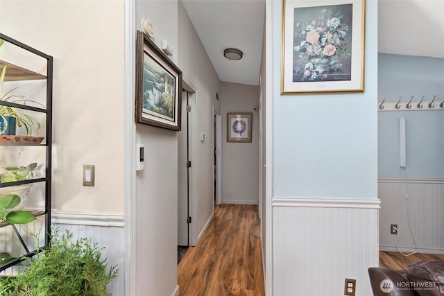 hallway with wood finished floors and wainscoting