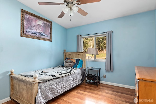 bedroom featuring ceiling fan, baseboards, and wood finished floors