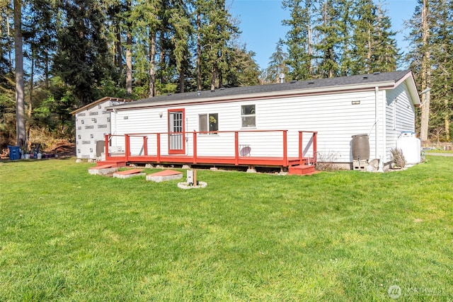 rear view of property with a wooden deck and a yard