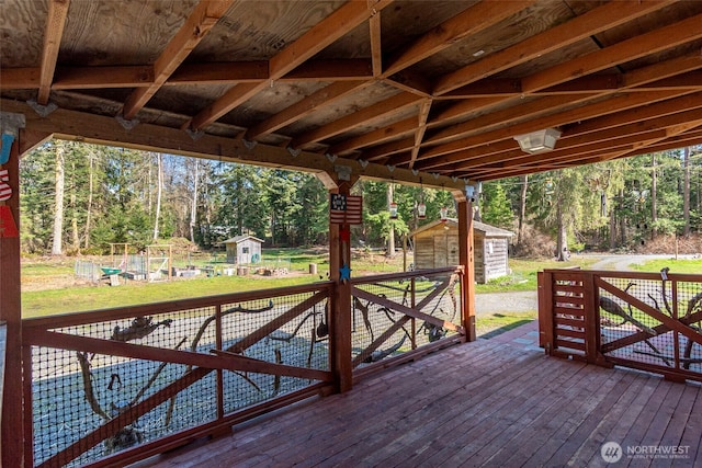 deck featuring an outdoor structure and a storage unit