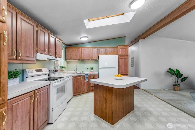 kitchen with white appliances, vaulted ceiling with skylight, under cabinet range hood, and light floors