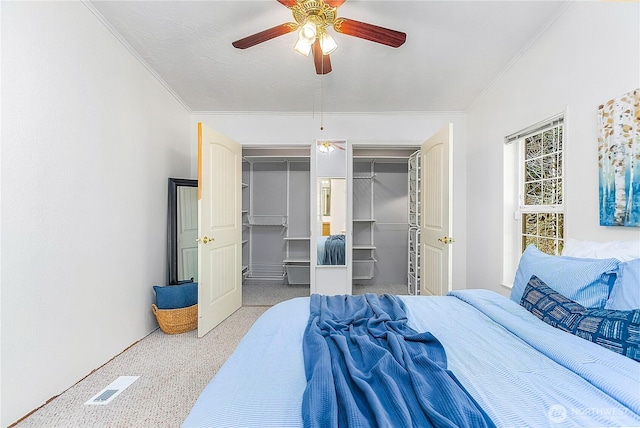 bedroom featuring ceiling fan, speckled floor, visible vents, and crown molding