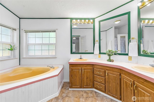 bathroom featuring double vanity, a sink, and a bath