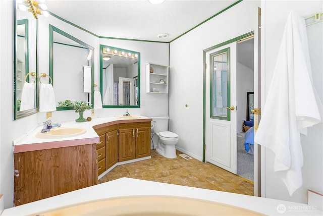 full bathroom featuring visible vents, a sink, toilet, and double vanity