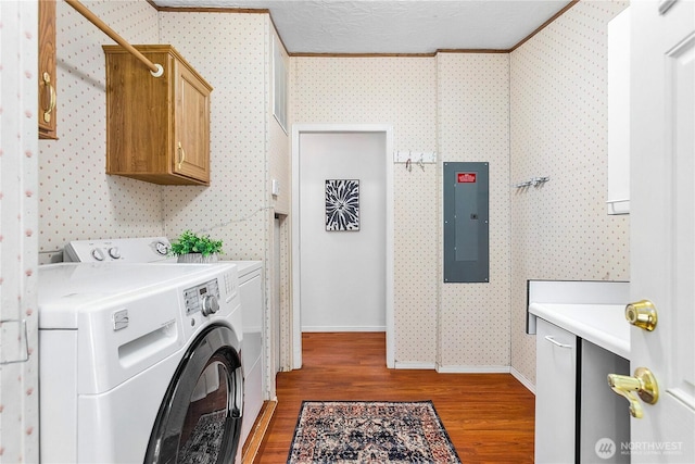 laundry room featuring wood finished floors, cabinet space, electric panel, washing machine and clothes dryer, and wallpapered walls