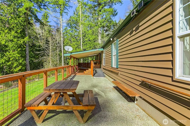 wooden terrace with a patio area