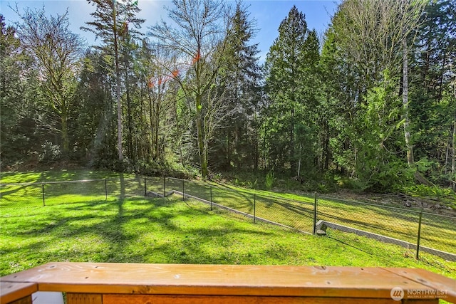 view of yard featuring fence and a view of trees