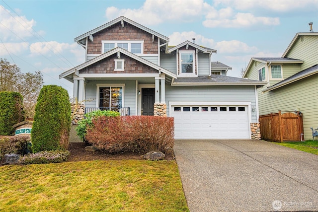 craftsman-style home with a garage, covered porch, fence, concrete driveway, and a front lawn