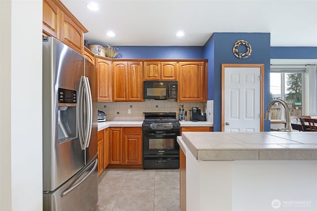 kitchen featuring light tile patterned floors, tasteful backsplash, recessed lighting, brown cabinetry, and black appliances