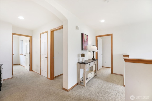 hallway with carpet floors, baseboards, arched walkways, and recessed lighting