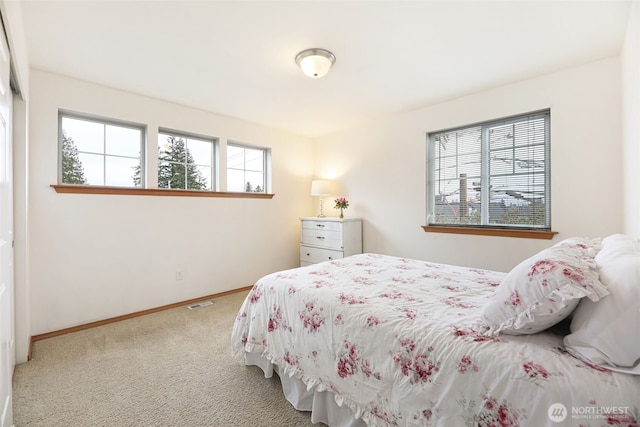 carpeted bedroom with visible vents and baseboards