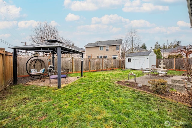 view of yard featuring a storage unit, a gazebo, a patio area, a fenced backyard, and an outdoor structure