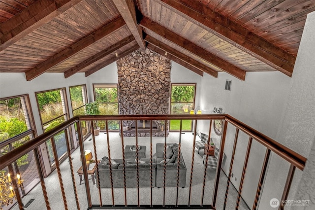 interior space with lofted ceiling with beams, wooden ceiling, carpet, and visible vents