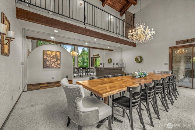 carpeted dining area with beam ceiling, a notable chandelier, wood ceiling, high vaulted ceiling, and baseboards