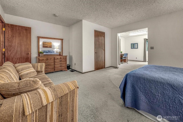 bedroom featuring light carpet and a textured ceiling