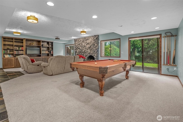 recreation room featuring recessed lighting, carpet, a textured ceiling, and a stone fireplace