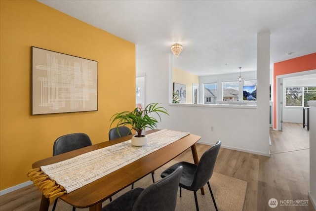 dining space featuring baseboards and wood finished floors