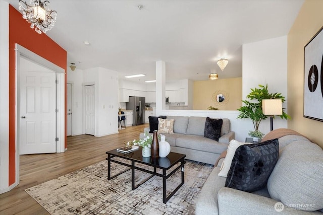 living room featuring a chandelier and light wood finished floors