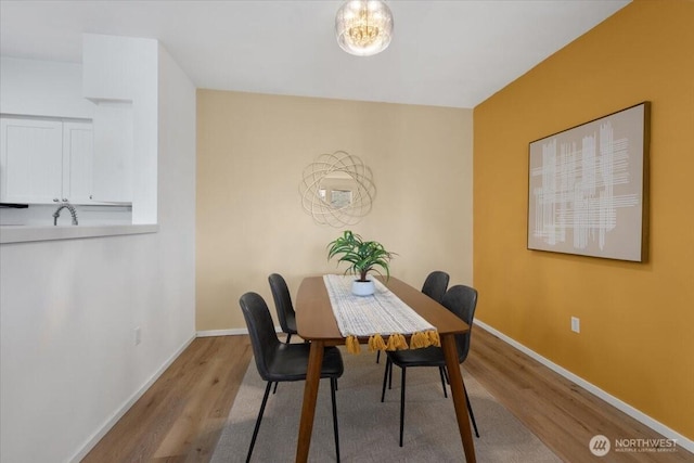 dining area with baseboards and wood finished floors