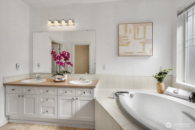 full bathroom featuring double vanity, a sink, and a bath