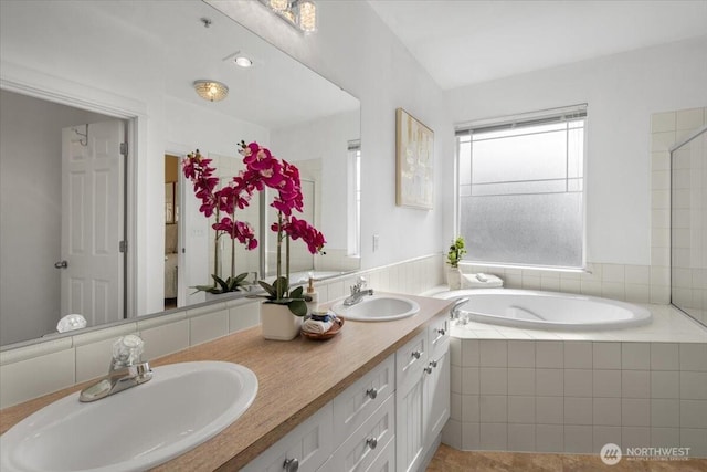 bathroom featuring a garden tub, a sink, and double vanity