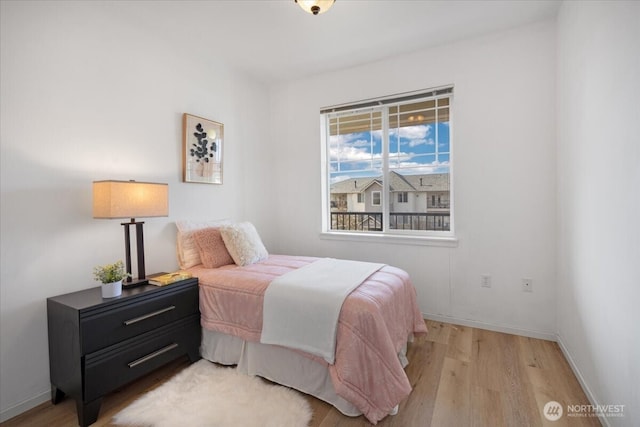 bedroom with light wood-type flooring and baseboards