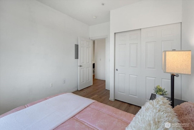 bedroom with a closet, baseboards, and wood finished floors