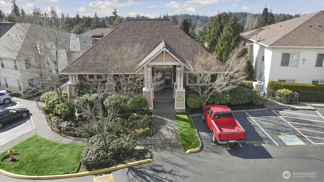 view of front of house featuring uncovered parking and a shingled roof