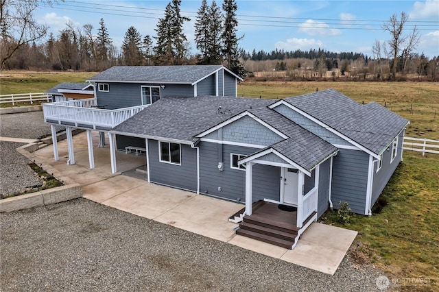 view of front of home featuring roof with shingles, a front yard, fence, driveway, and a wooden deck