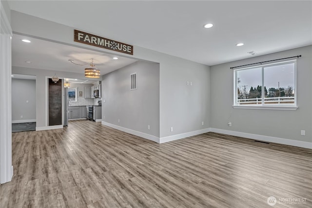 unfurnished living room featuring light wood-style floors, baseboards, and recessed lighting
