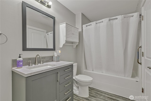full bath featuring shower / bath combination with curtain, vanity, toilet, and wood finished floors
