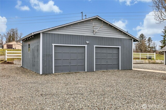 detached garage featuring fence