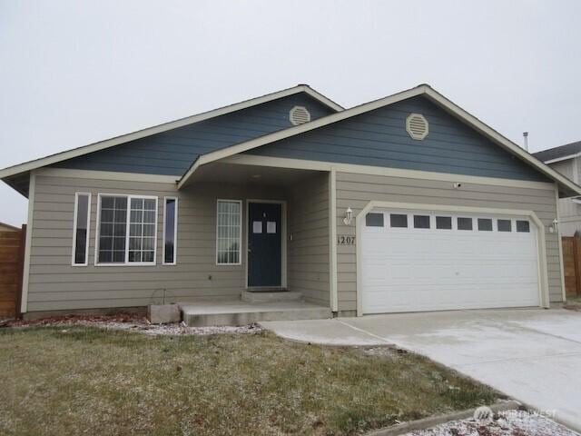 view of front facade with concrete driveway, fence, and an attached garage