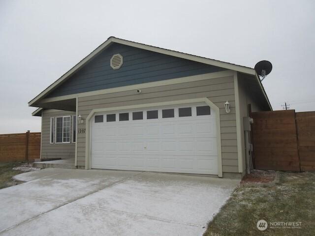 garage with driveway and fence