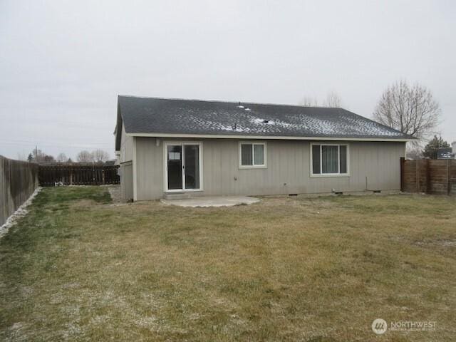 back of property with a patio area, a fenced backyard, and a lawn